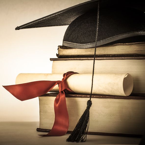 Graduation cap, scroll, and books