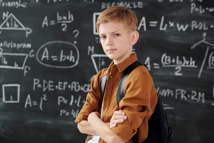 Teen boy standing in front of chalkboard