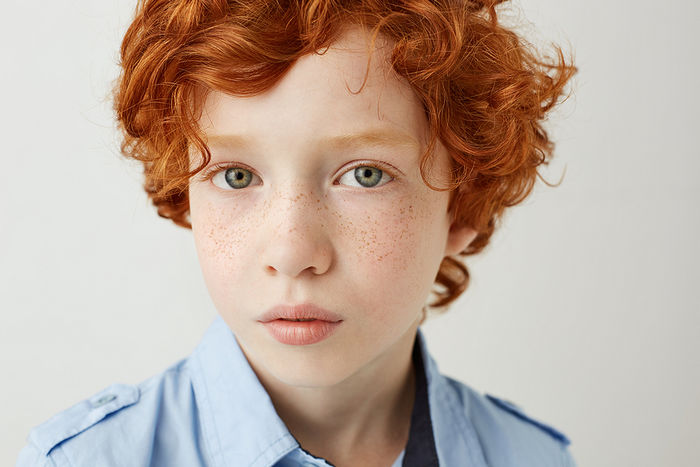 Head and shoulders shot of boy with curly red hair