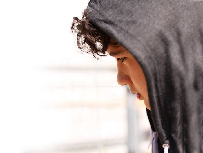 Sad, troubled teen boy in hoodie