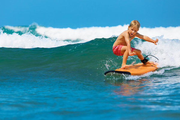 A young surfer learning to ride his board