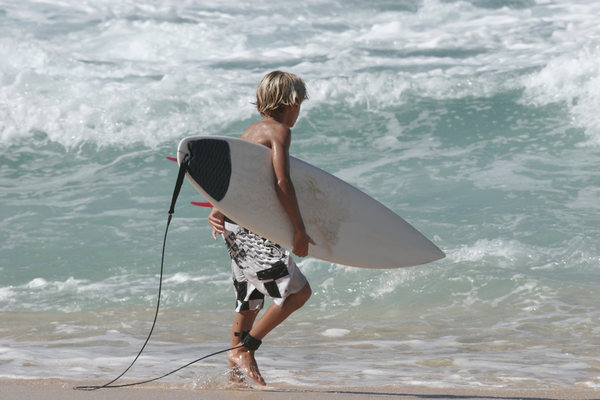 Young boy going surfing