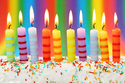 Cake with ten candles on rainbow background