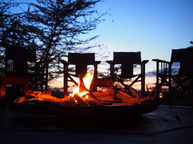 Empty chairs around a campfire