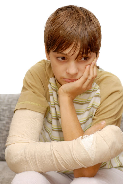 Boy with broken arm looking sad
