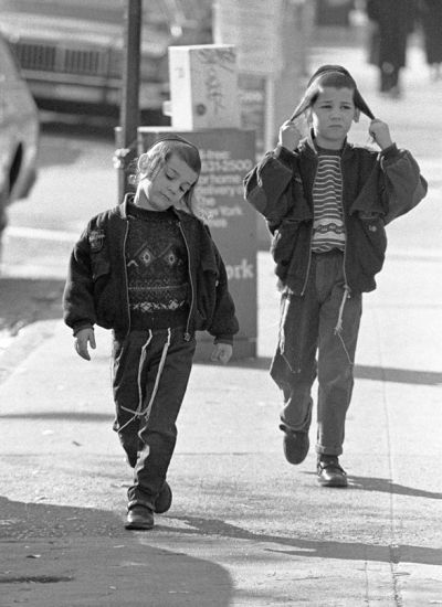 Two children walking along the street