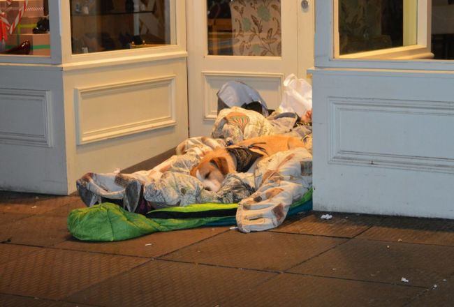 A person sleeping rough in a shop doorway