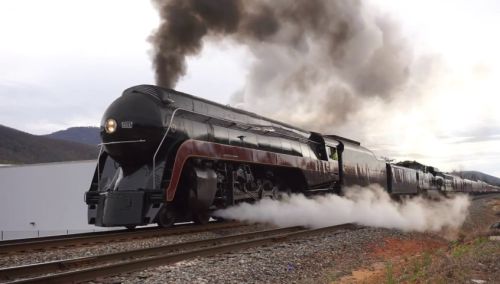 A steam train laboring uphill