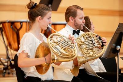 Woman and man playing French horns