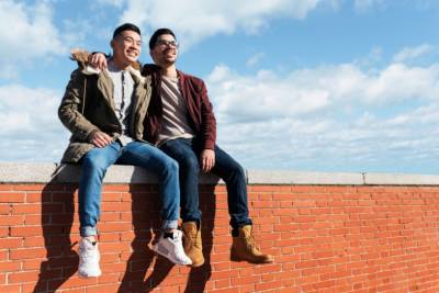 Two young men sitting on a wall