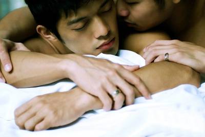 Two young men embracing while lying down