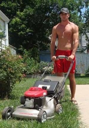 Young man mowing grass