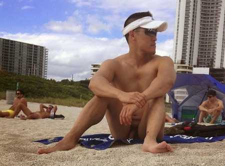 Nude man sitting on beach