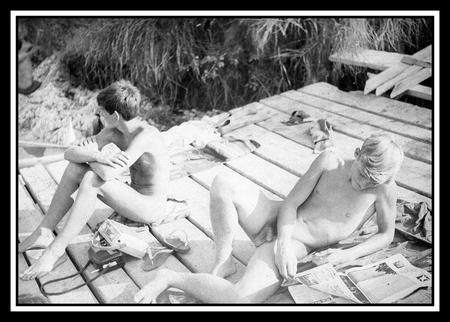 Two young men lounging naked on a dock