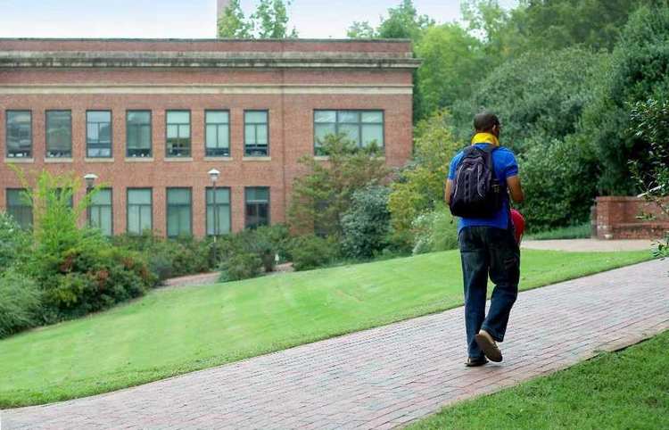 Young man walking up path on campus